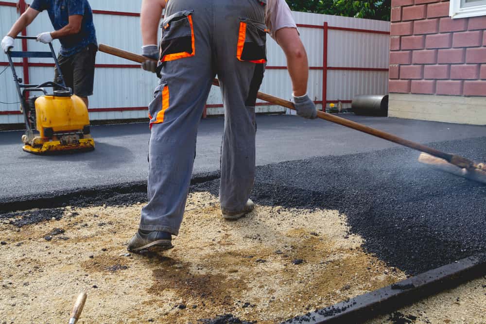 Illustration of a freshly paved asphalt driveway with a road roller